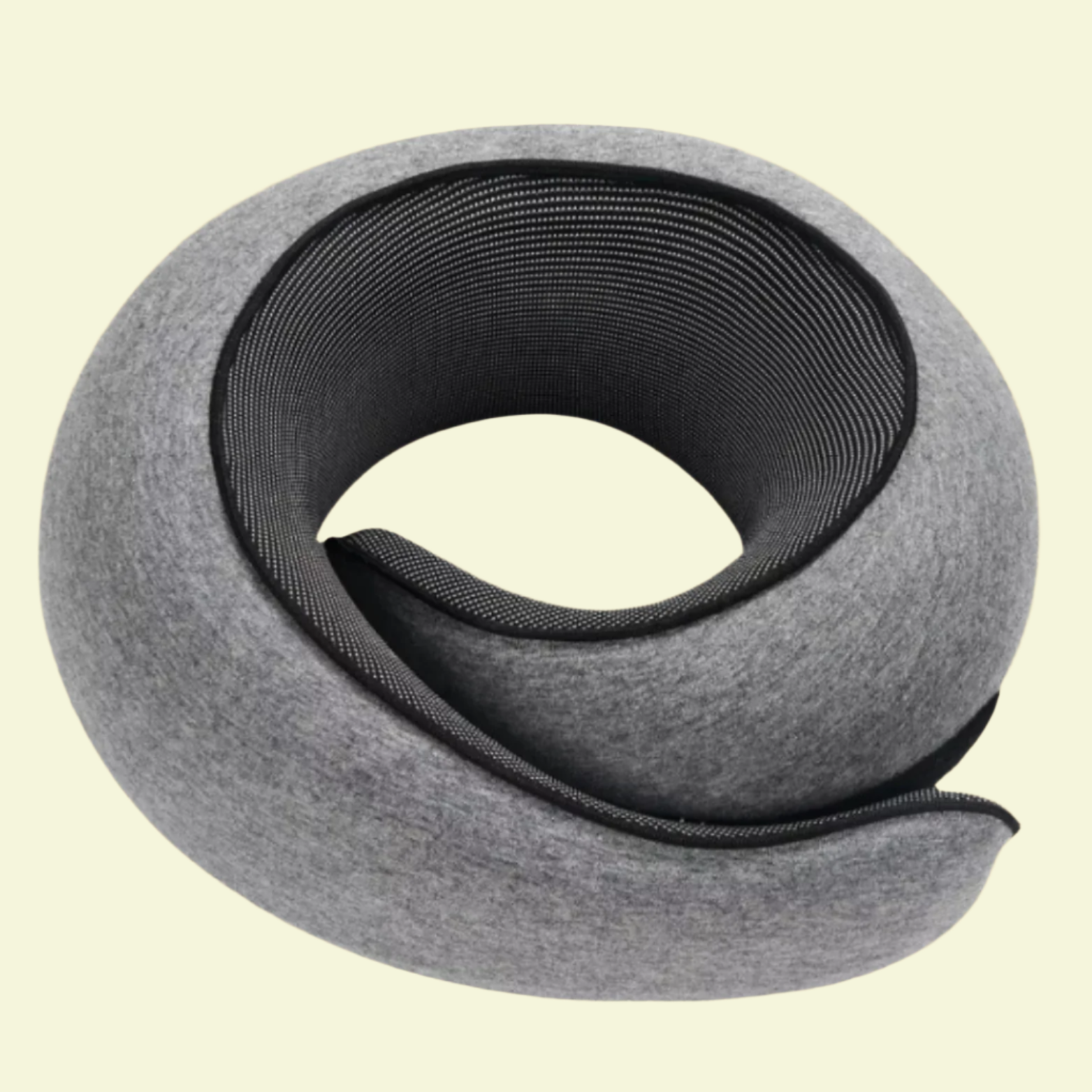A rolled-up memory foam neck support pillow with a gray cover, coiled in a spiral shape.