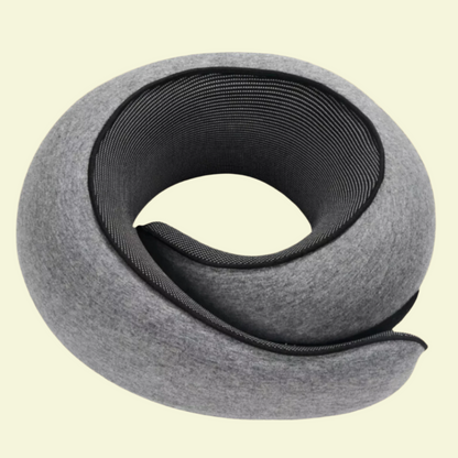 A rolled-up memory foam neck support pillow with a gray cover, coiled in a spiral shape.