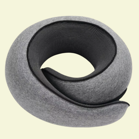 A rolled-up memory foam neck support pillow with a gray cover, coiled in a spiral shape.